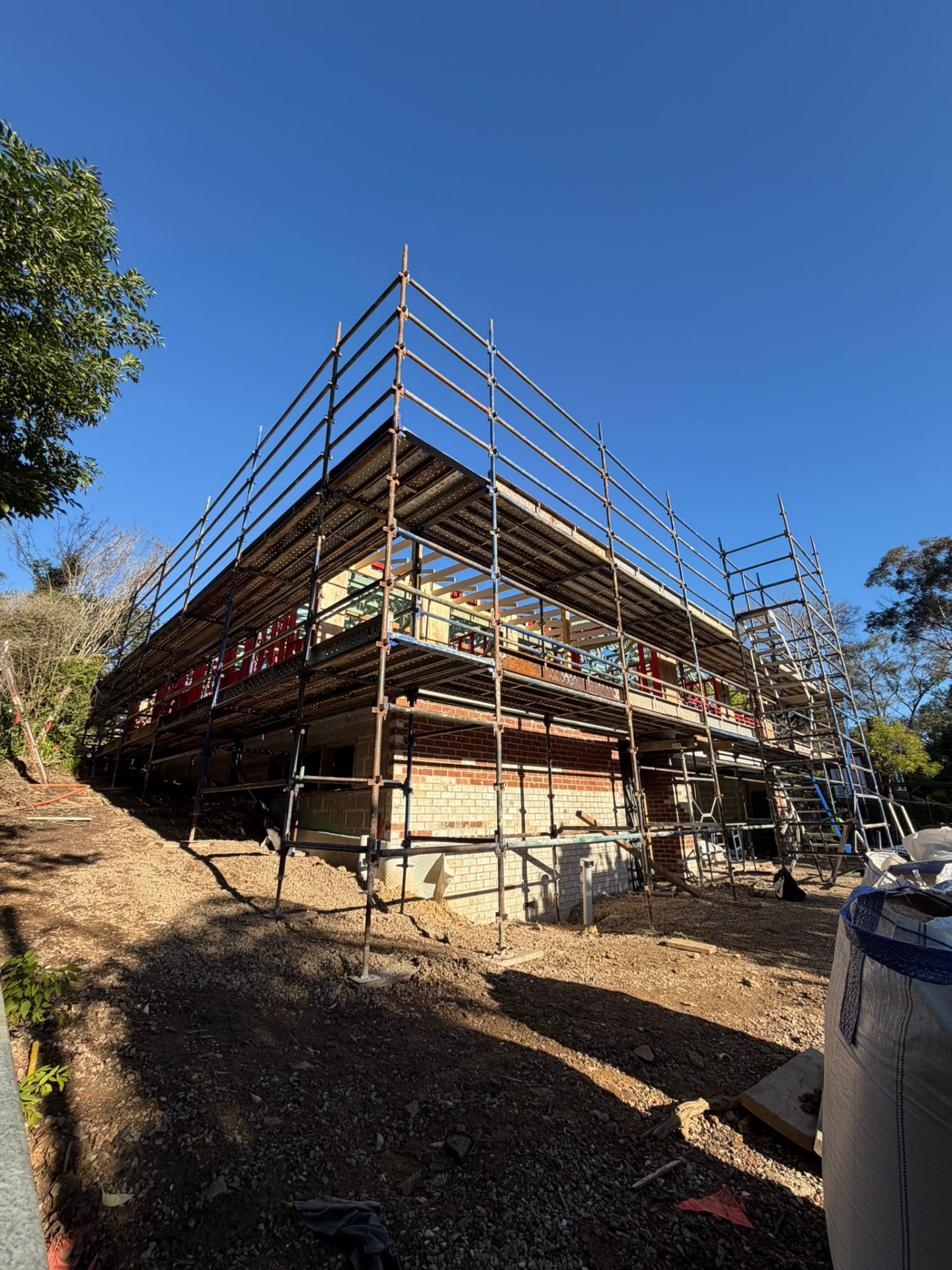 Corner view of Mounty County scaffolding around a brick home under construction